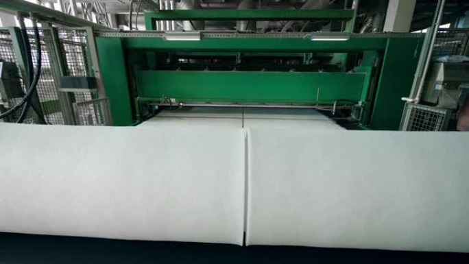 聚酯棉絮在工作中的输送机上卷成大线圈。