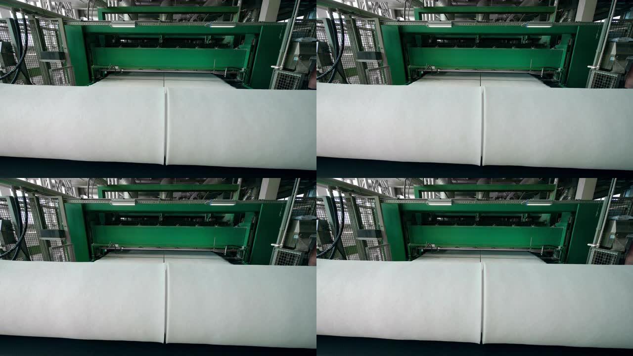 聚酯棉絮在工作中的输送机上卷成大线圈。
