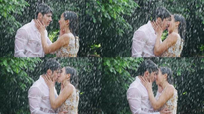 恋爱中的年轻无忧无虑夫妇的慢动作在绿树的背景下在雨中拥抱和亲吻