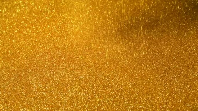 闪闪发光的金粉倒在金表面上