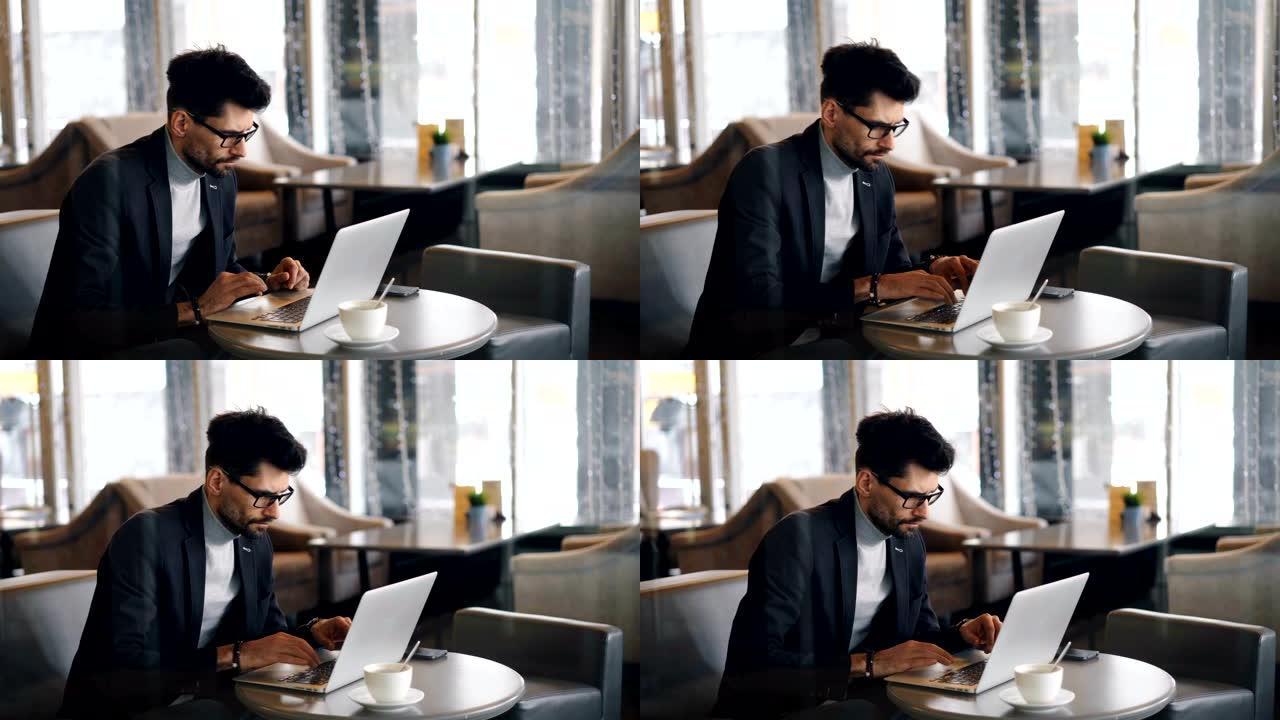 公司经理在午休期间使用现代笔记本电脑在咖啡馆工作