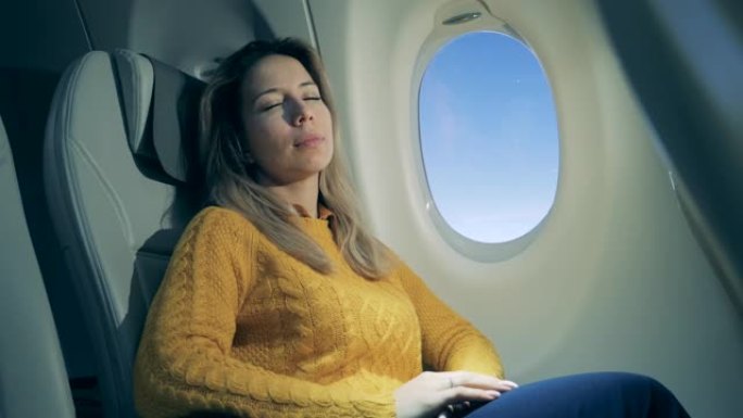 飞行过程中，熟睡的女人坐在窗户旁边