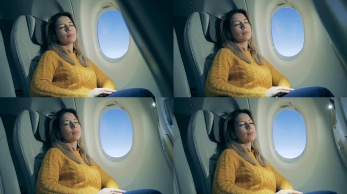 飞行过程中，熟睡的女人坐在窗户旁边