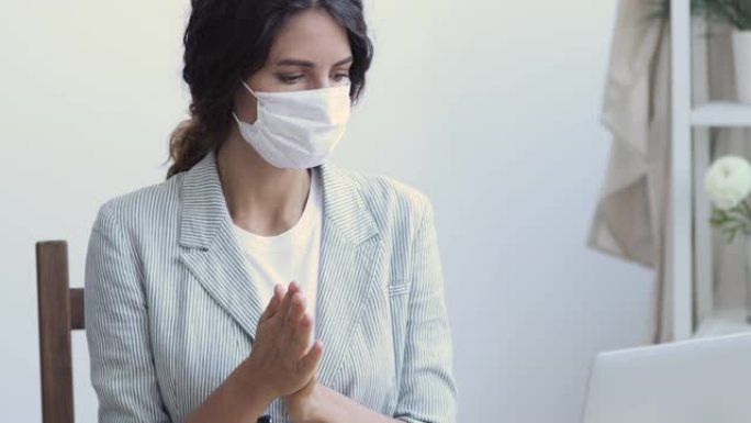 女上班族戴口罩用消毒剂消毒双手