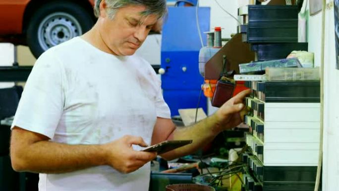 男性机械师在使用数字平板电脑4k时检查备件