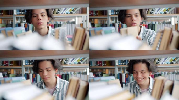 英俊的十几岁男孩学生在大学图书馆选书的特写