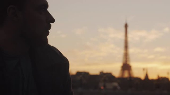 体贴的欧洲年轻人的特写日落肖像直视巴黎埃菲尔铁塔天空风景慢动作。