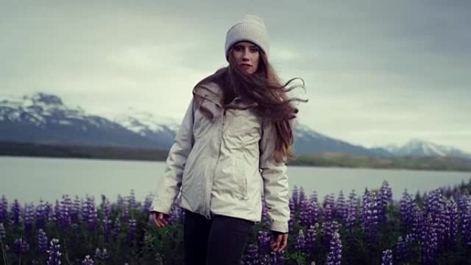 享受冰岛夏天的女人。草地上满是盛开的羽扇鱼