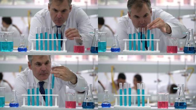实验室的男科学家用蓝色液体抓住试管