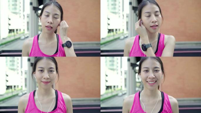 健康美丽的年轻亚洲运动员女子在城市跑步时使用智能手机听音乐。生活方式女性在城市概念中锻炼。