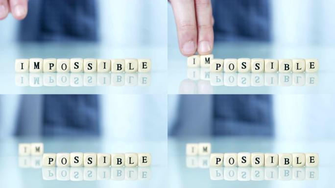 一只手把单词 “不可能” 变成 “可能” 扔掉字母。