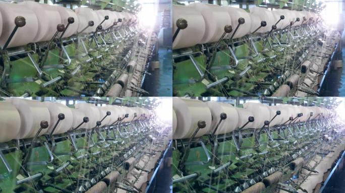 金属机器在纺织厂与线一起工作，将它们盘绕到线轴上。