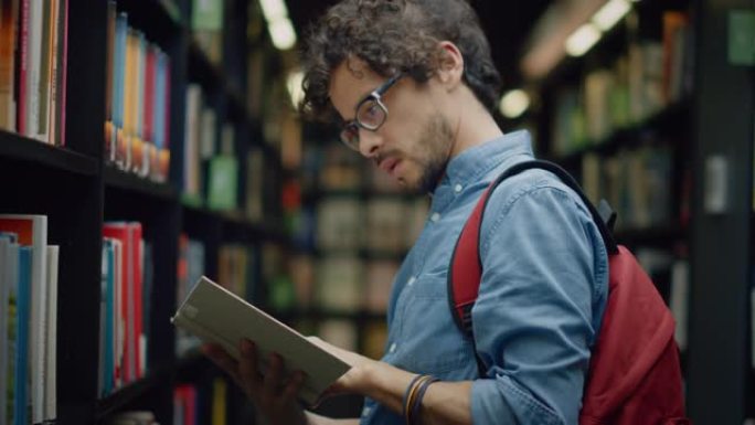 大学图书馆: 有天赋的亚洲男孩的肖像走在成排的书架之间寻找合适的书名，找到并挑选一个用于课堂作业和考