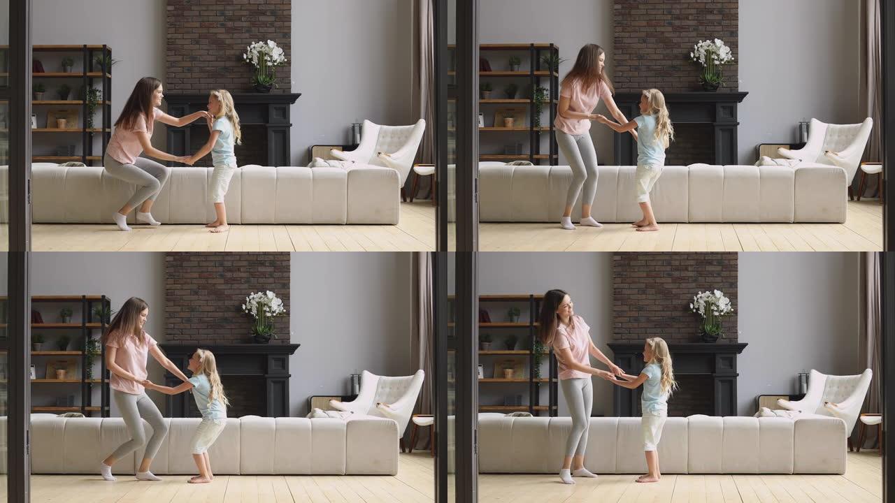 活跃的妈妈和小女儿在客厅一起跳舞