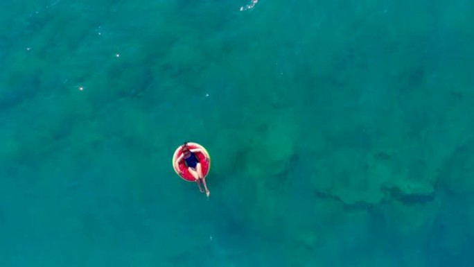 一个女人漂浮在海上的橡胶圈上。