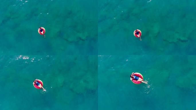 一个女人漂浮在海上的橡胶圈上。