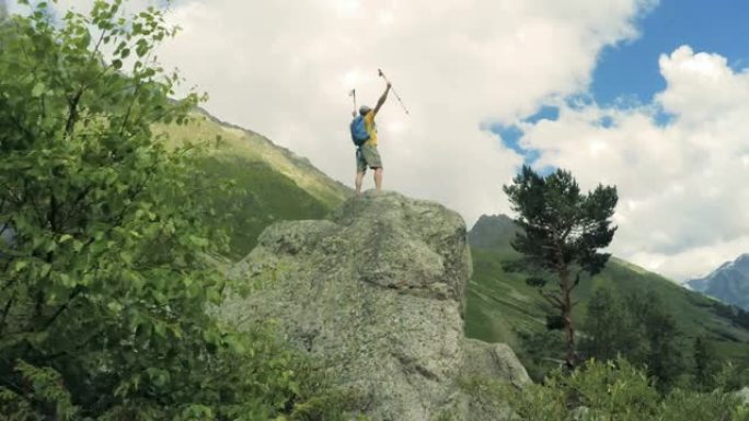 到达顶峰。快乐的男人站在山顶上