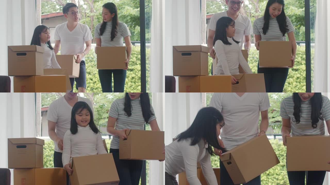 快乐的亚洲年轻家庭买了新房子。日本妈妈、爸爸和孩子微笑着快乐地拿着纸板箱，用于移动物体走进现代大家庭