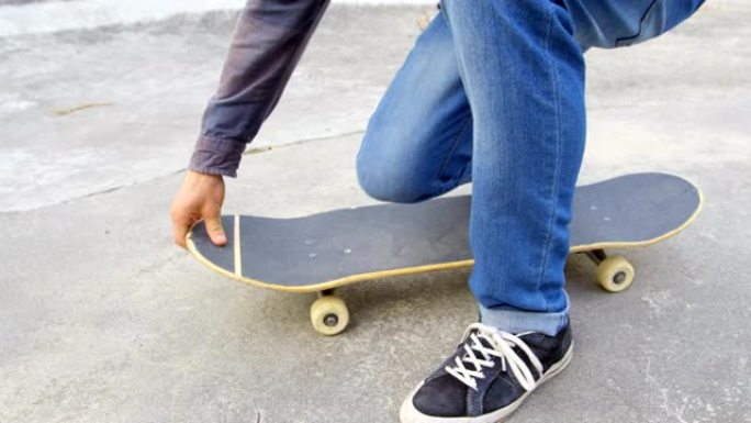 低矮的年轻人在滑板公园4k蹲在滑板上系着鞋带