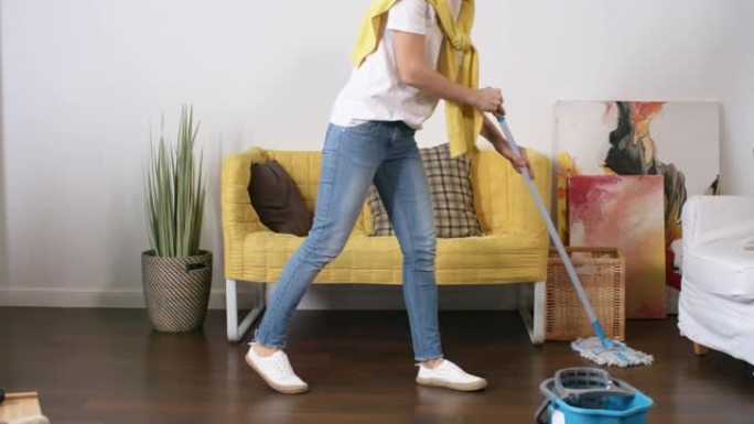中年白人妇女用拖把在新家洗地板