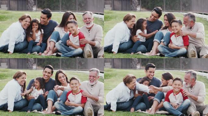 三代家庭坐在公园的草地上，互相挠痒痒，对着镜头微笑