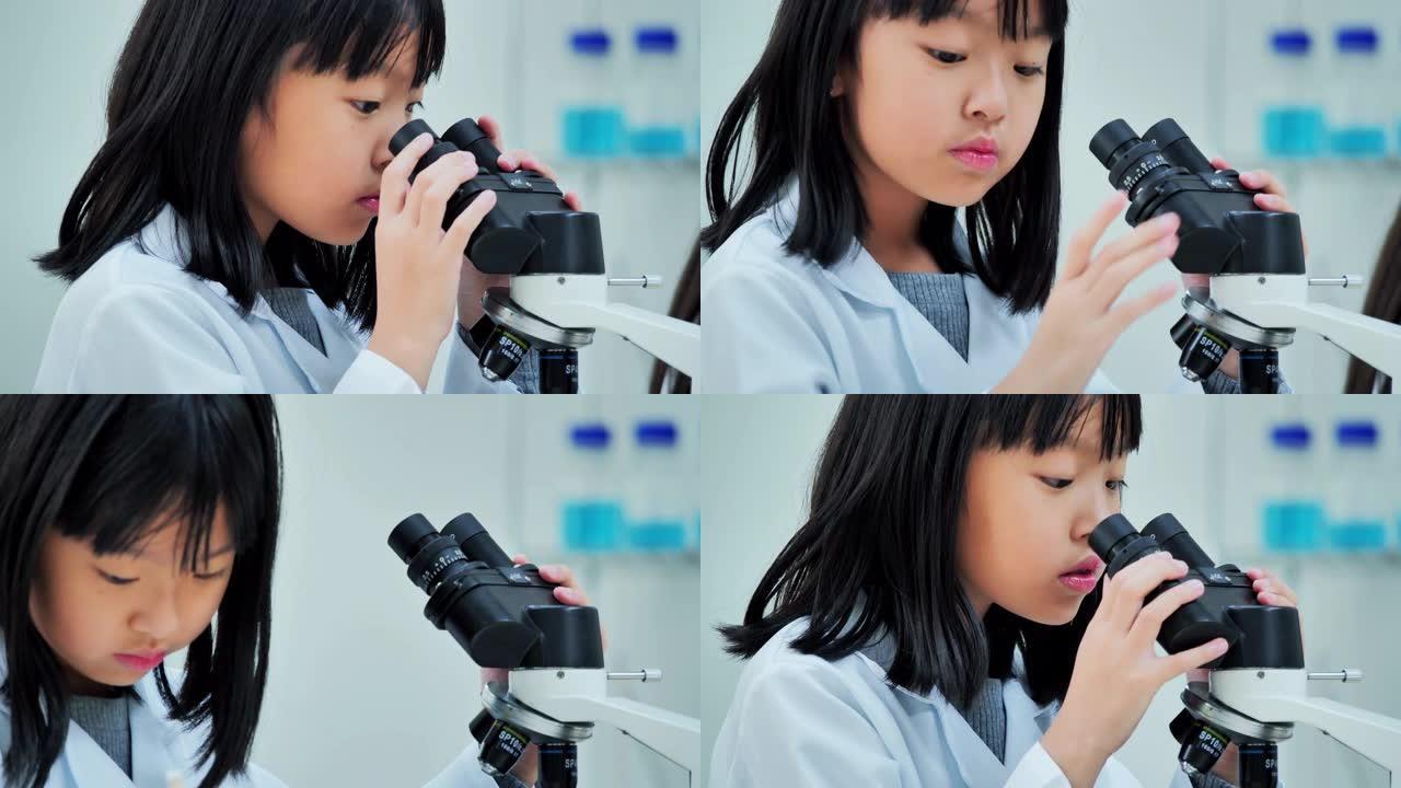 理科学生在学校的实验室里用显微镜看孩子。老师和好奇的学生在教室实验室进行科学实验。教育，技术，团队合