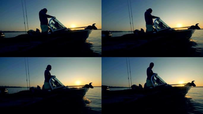 两名垂钓者在日出时驾驶汽艇钓鱼