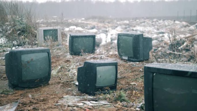 冬天垃圾填埋场上有许多坏掉的电视。