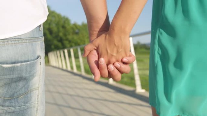 特写: 情侣在公园浪漫散步时的双手特写镜头