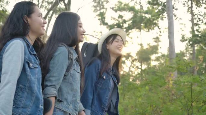 慢动作 -- 一群年轻的亚洲女孩在乡村徒步旅行。徒步旅行者在树林里露营。旅行和友谊概念。