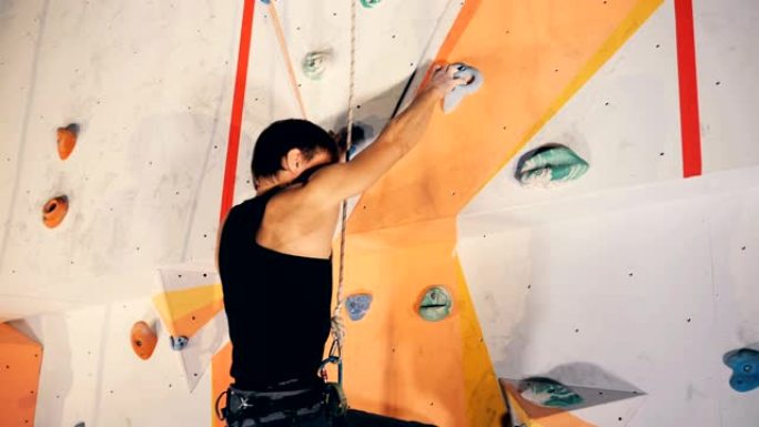 成年登山者在训练墙上，特写。