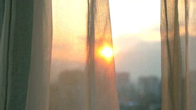 日出时的窗帘窗外太阳早晨太阳升起
