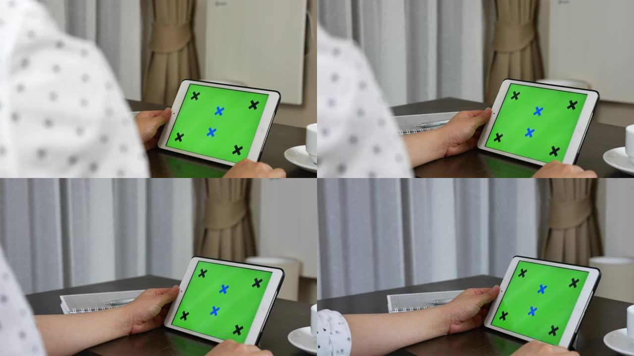 使用数字平板电脑拍摄女性的肩膀，绿屏