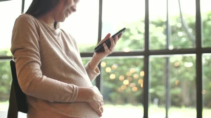 孕妇在手机上发送消息，使用智能手机