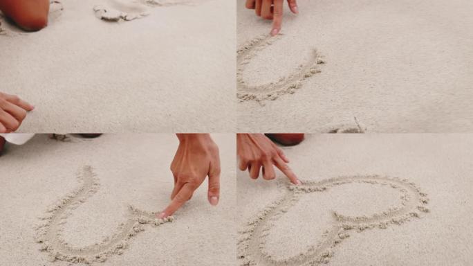 女人用手指在沙子上画心形