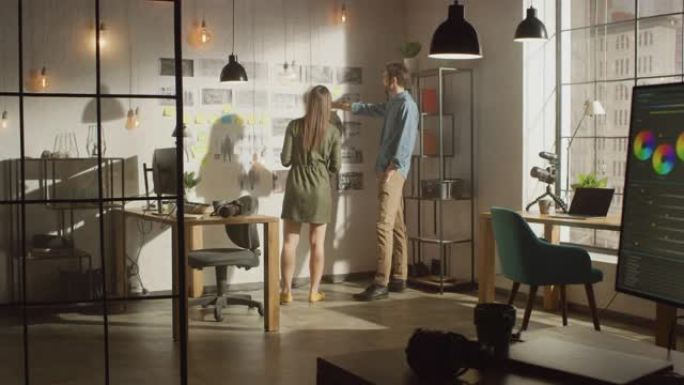 年轻的有创造力的男性和女性正在他们凉爽的办公室阁楼的墙上组织一个情绪板。图片代表未来的运动视频。同事
