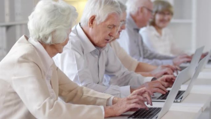 快乐的老年人使用笔记本电脑和聊天