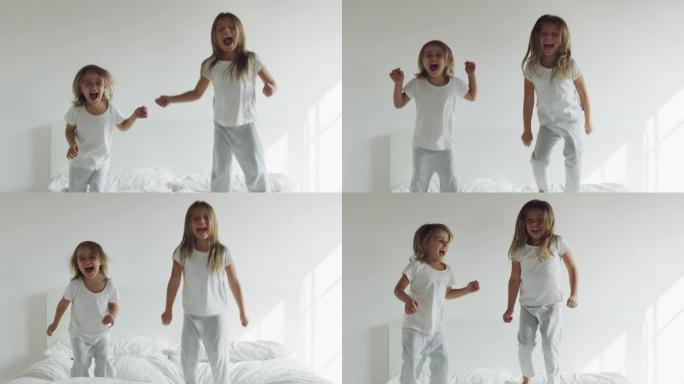 两个姐妹穿着白色睡衣，跳上床，玩得很开心。