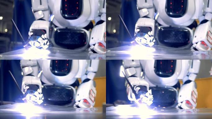 白色机器人焊接在金属板上，特写。