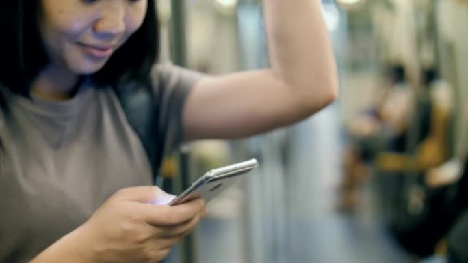 在地铁交通中使用智能手机的女人