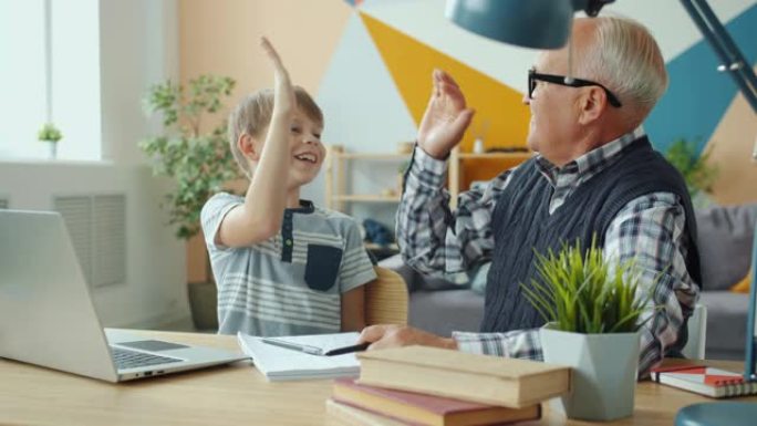 快乐的孩子和爷爷一起做作业-五岁表示竖起大拇指