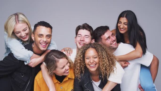 团体工作室拍摄的年轻的多元文化朋友在慢动作中微笑和嘲笑镜头