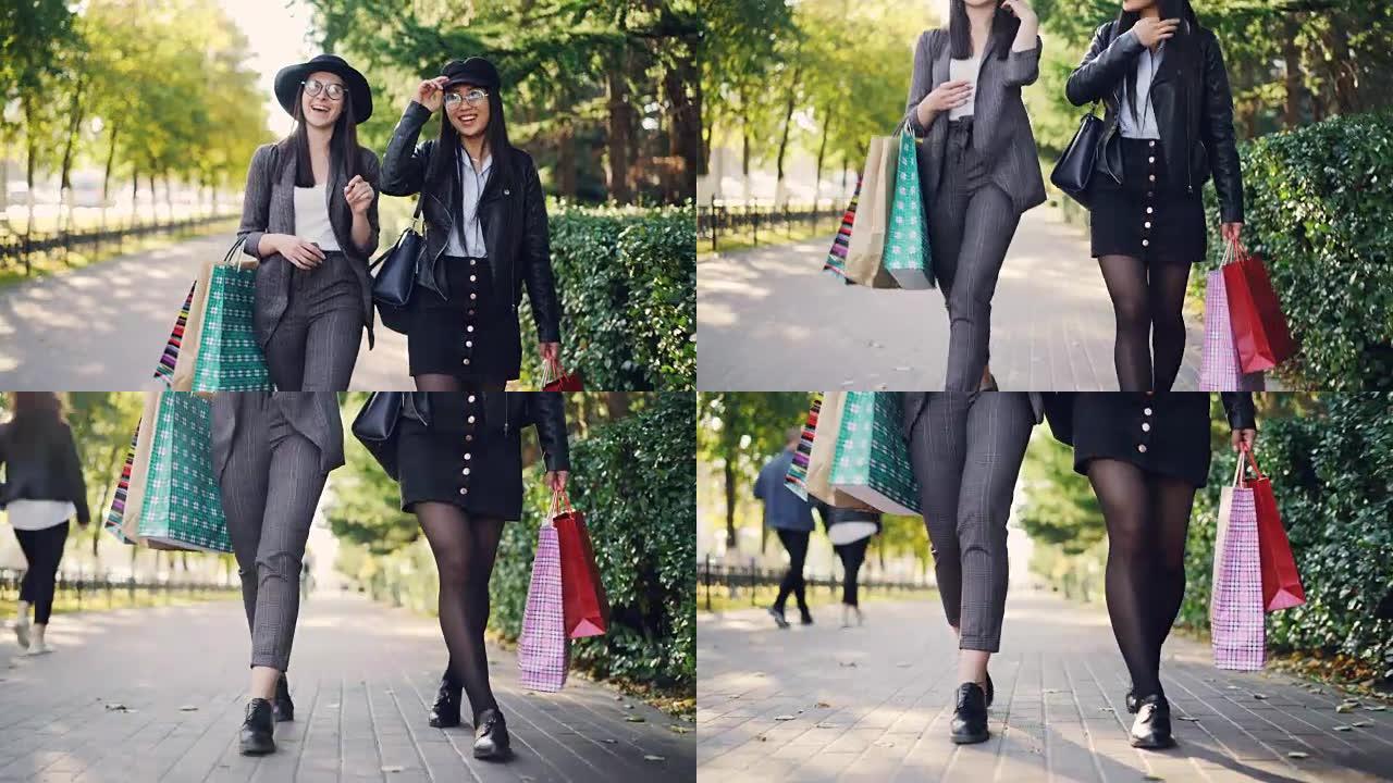 倾斜拍摄快乐的女性千禧一代购物狂和明亮的购物袋一起散步，聊天。女人穿着时髦的服装和眼镜。
