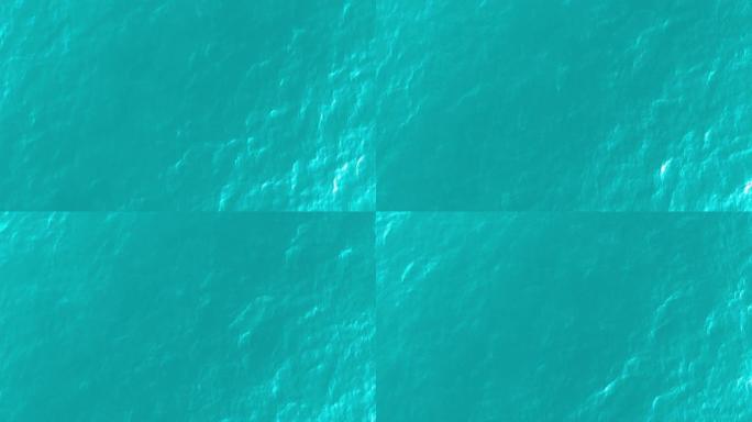 从绿色海水纹理的高空俯视。摄像机飞过水面，一览表水面。水面的背景。4k鸟瞰图
