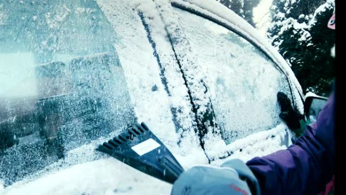 女司机刮雪覆盖车窗