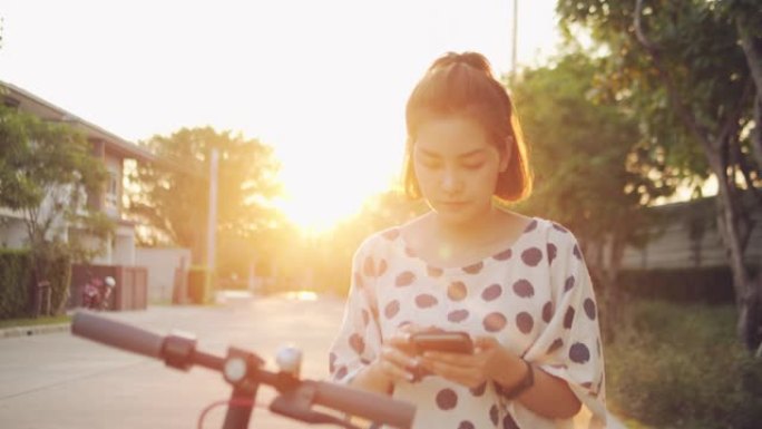 年轻女子用电动滑板车在智能手机上搜索地图