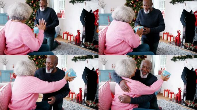 高级黑人给他的伴侣送了一份圣诞礼物，然后他们互相拥抱，前视图