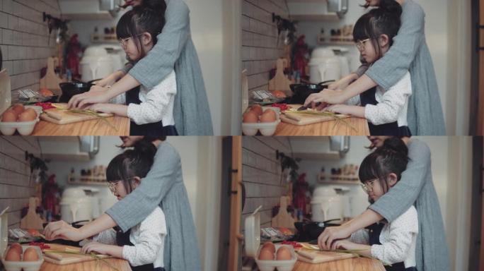 千禧一代的母亲用女儿的帮助手在家做饭煎蛋卷在厨房准备早餐。