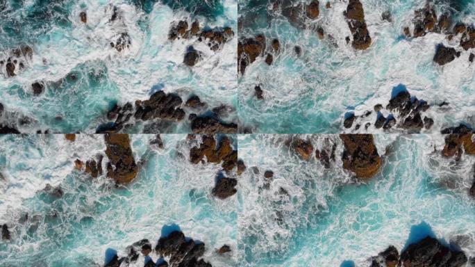 波浪在石头上破碎。海浪起泡和飞溅的海浪。空中俯视图。4K, UHD