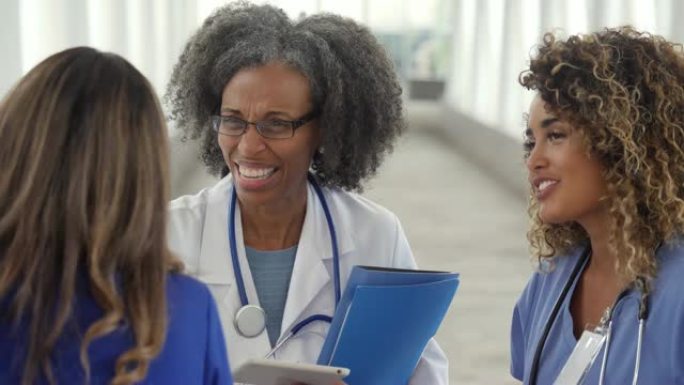 一群女性医疗保健专业人员在医院走廊交谈